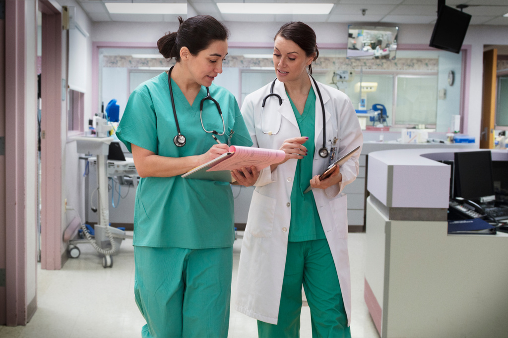 Doctor and nurse talking in hospital hallway
